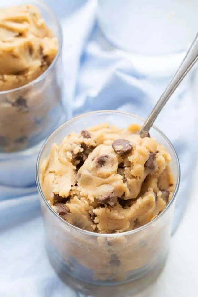 edible cookie dough in a glass cup with a spoon