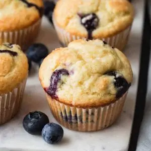 angled view of blueberry muffins on a marble board