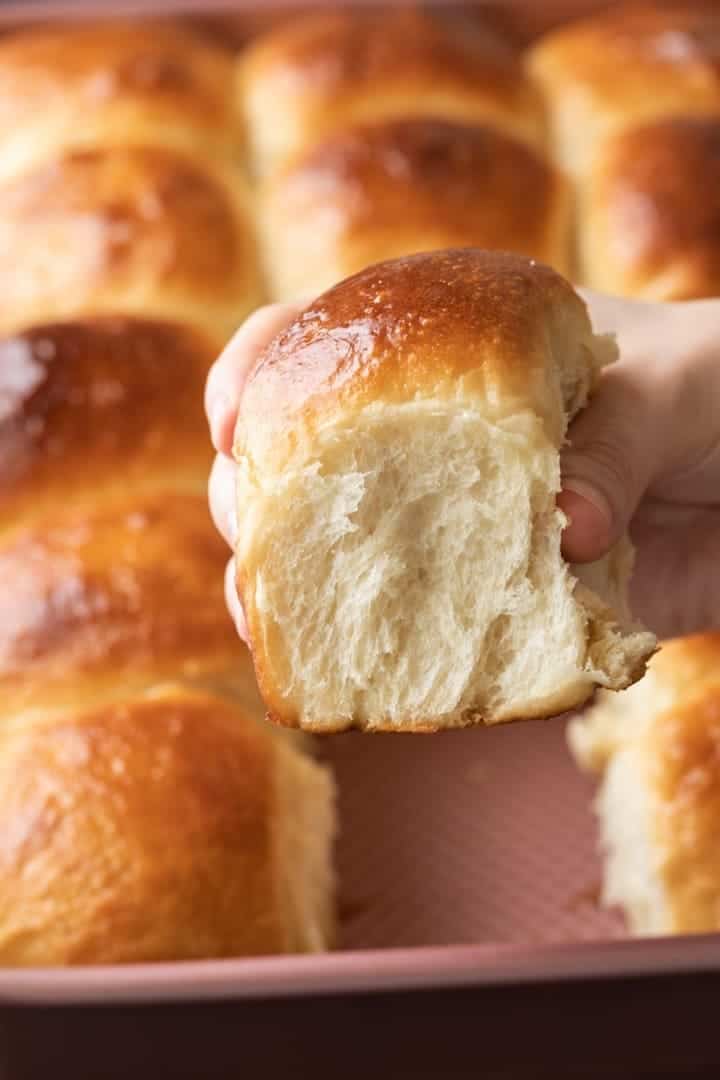 hand holding a Hawaiian Sweet Roll so the fluffy side is visible