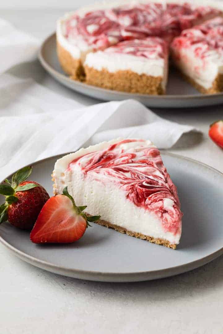 side view of a slice of no bake cheesecake on a light blue plate with fresh strawberries