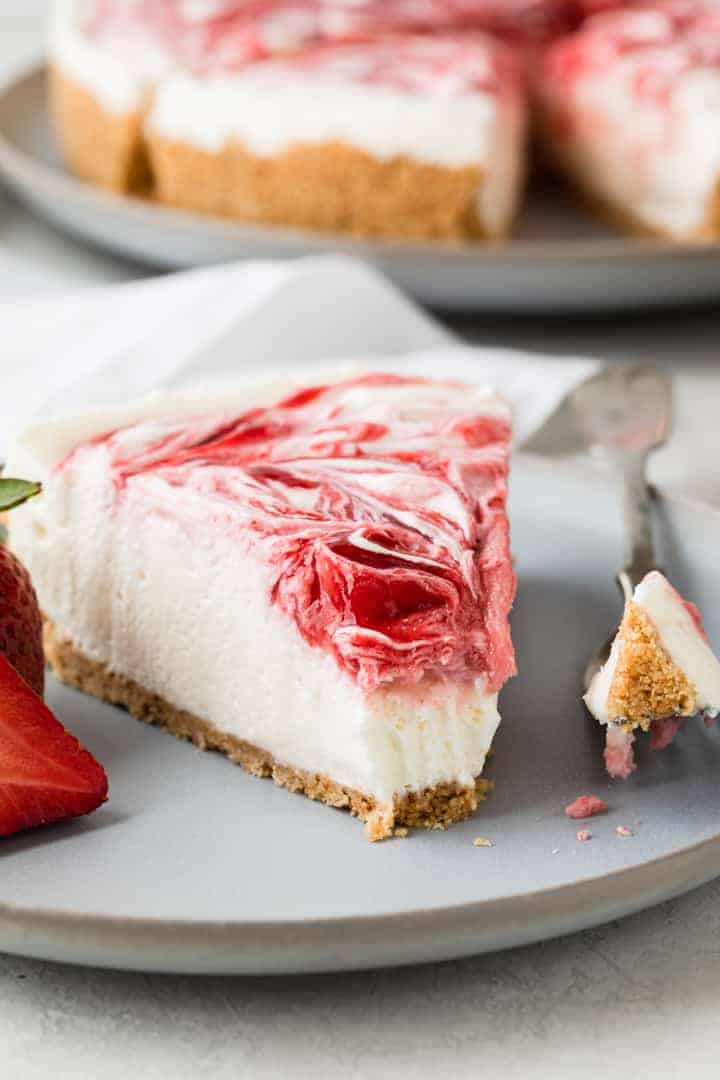 side view of no bake strawberry cheesecake slice with a bite taken out