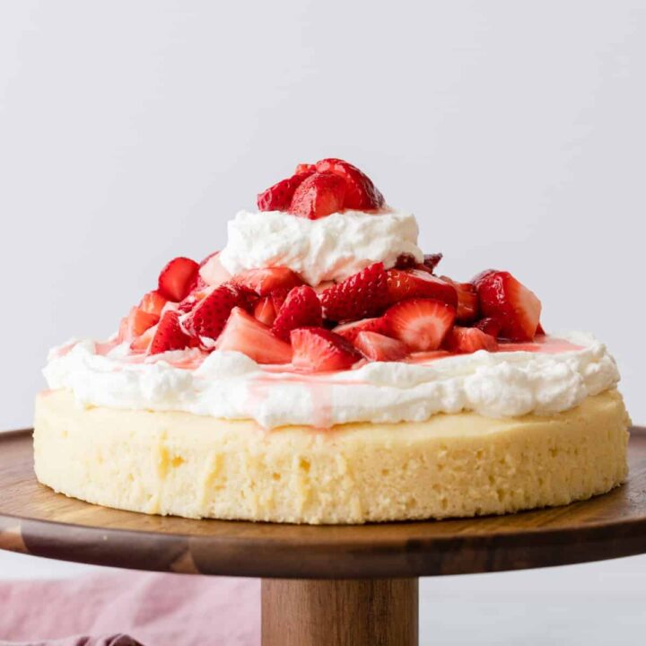 single layer strawberry shortcake cake on a wooden cake stand