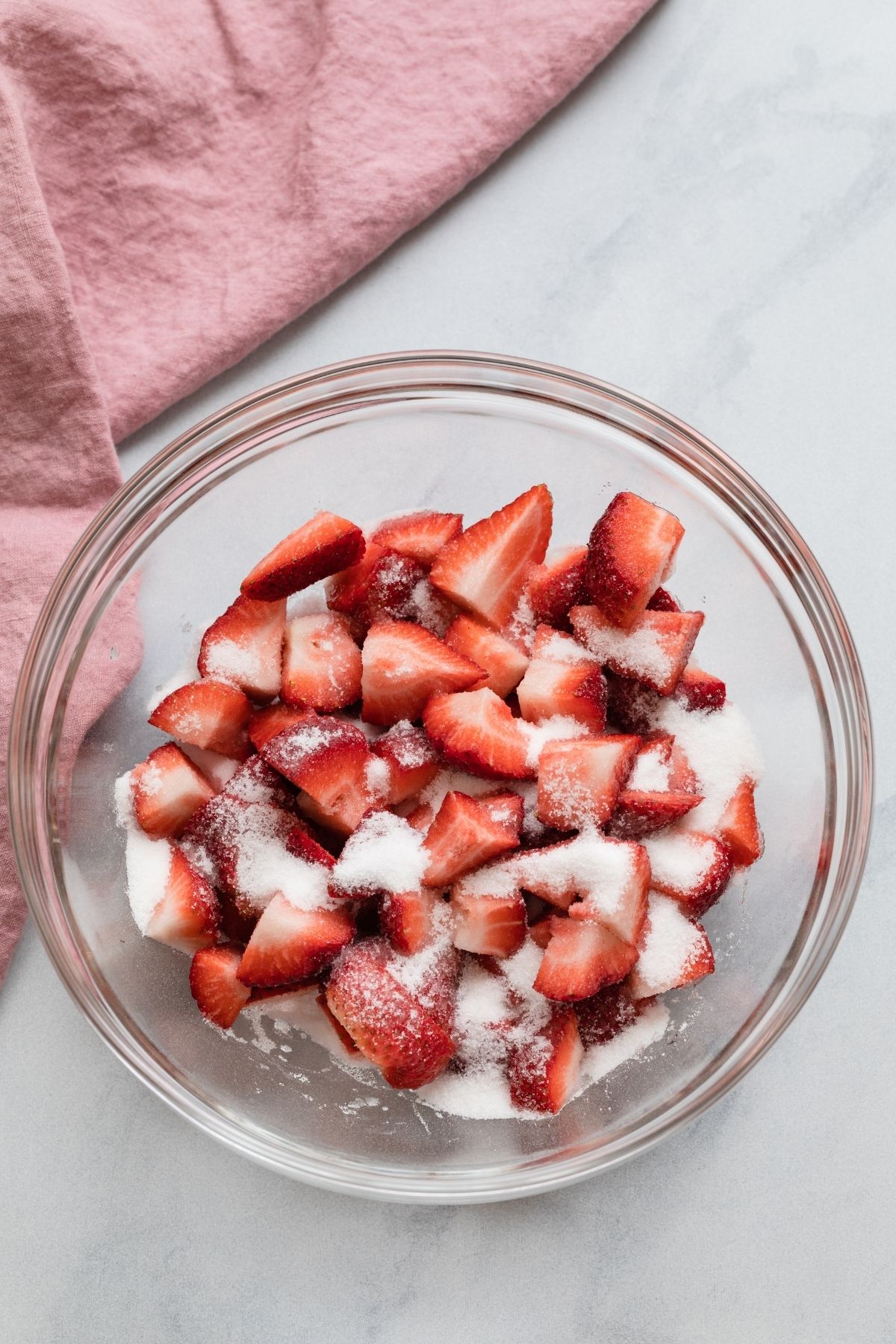 Chopped strawberries and sugar in bowl.