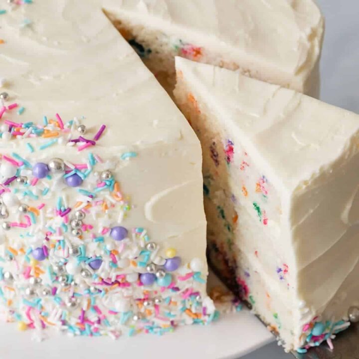 angled view of funfetti cake with slice being taken out