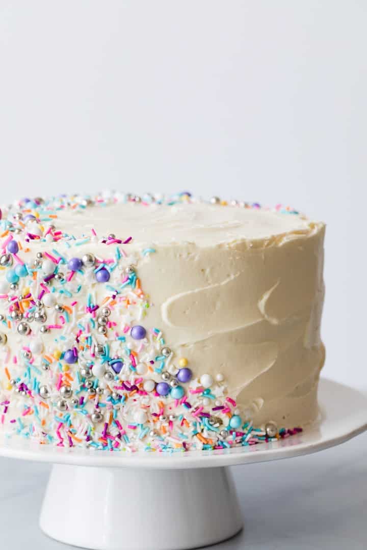side view of frosted funfetti cake decorated with colorful sprinkles