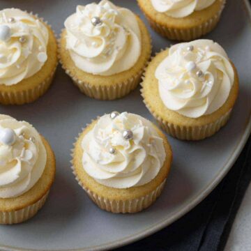 vanilla cupcakes with vanilla frosting on a gray plate
