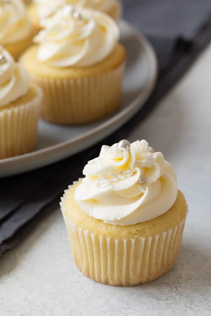 angled view of a vanilla cupcake with vanilla frosting