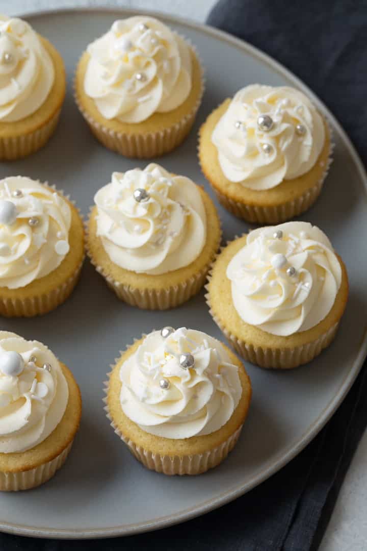 vanilla cupcakes with vanilla frosting on a gray plate