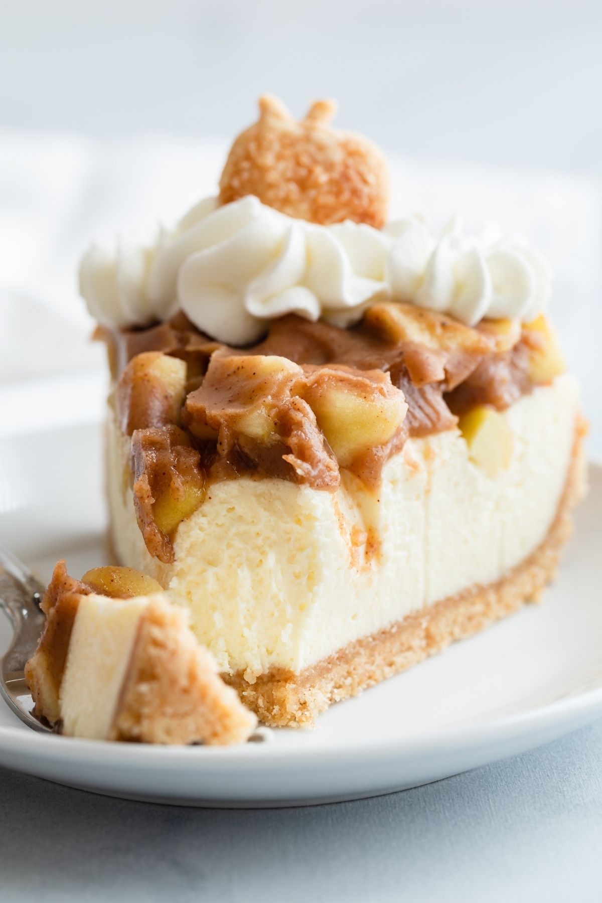 close up of a slice of apple pie cheesecake with a bite taken out