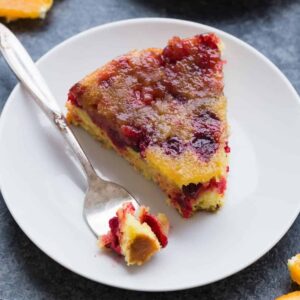 Cranberry orange upside down cake on white plate with fork