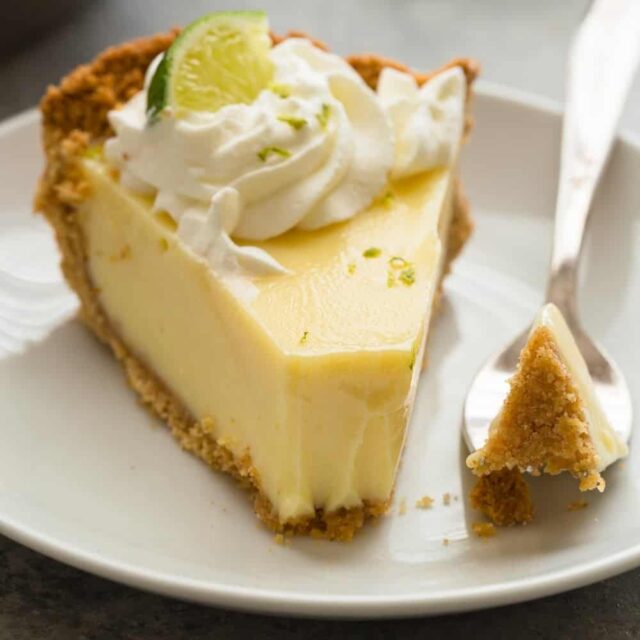 Slice of lime pie with fork taking a piece out