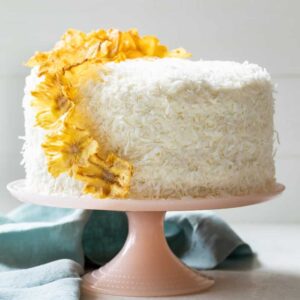 Pineapple coconut cake with pineapple flowers on pink cake stand