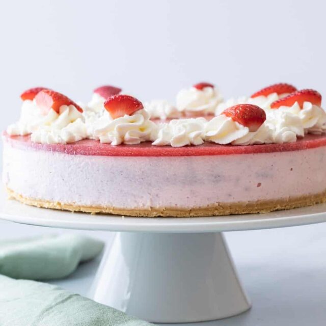 Strawberry mousse cake on white cake stand