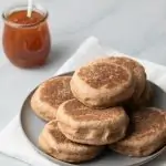 angled view of whole wheat English muffins on grey plate