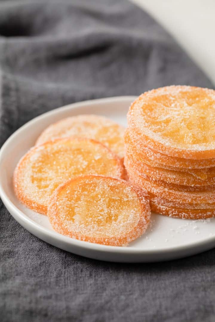 candied orange slices on a white plate over a grey napkin