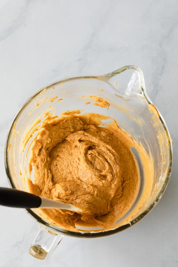 pumpkin cupcake batter in a glass mixing bowl