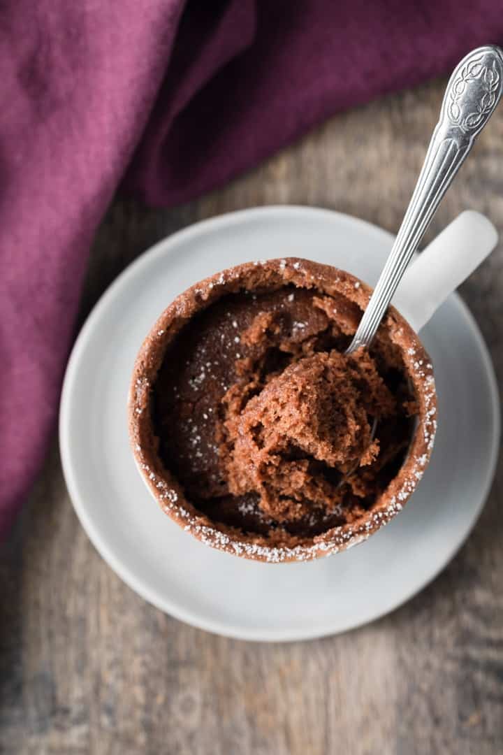 overhead of a spoon taking a bite out of nutella mug cake