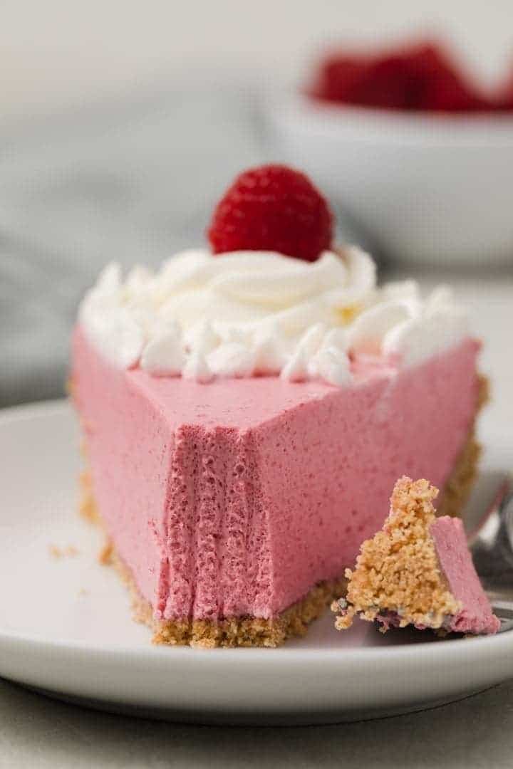 slice of raspberry pie with fork taking a bite out