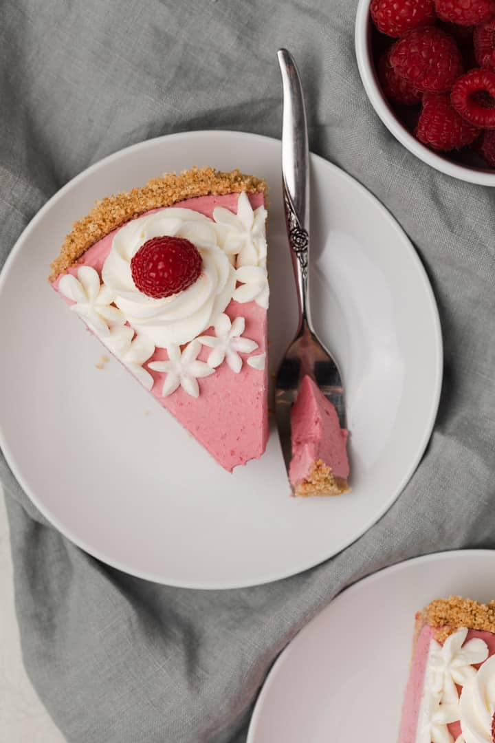 overhead view of slice of raspberry pie on white plate
