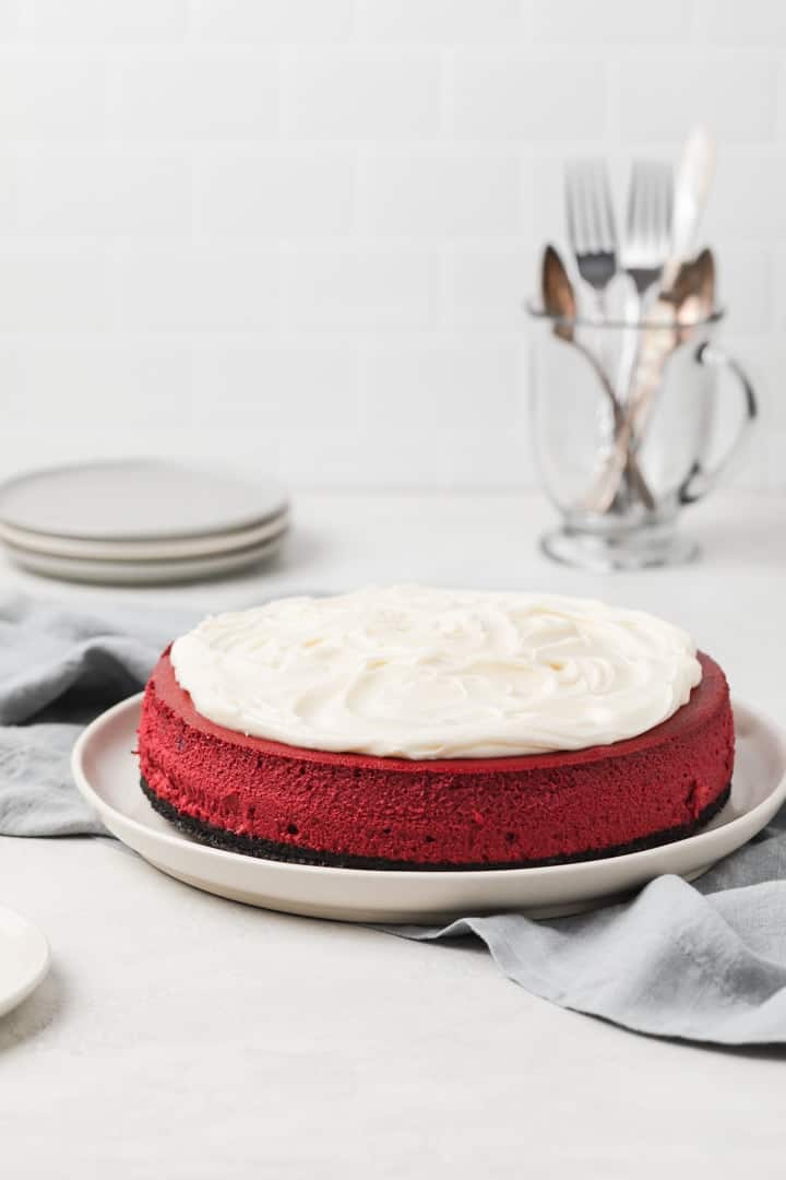 side view of red velvet cheesecake on a white plate