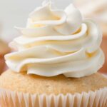 close up of swiss meringue buttercream swirled on top of cupcake
