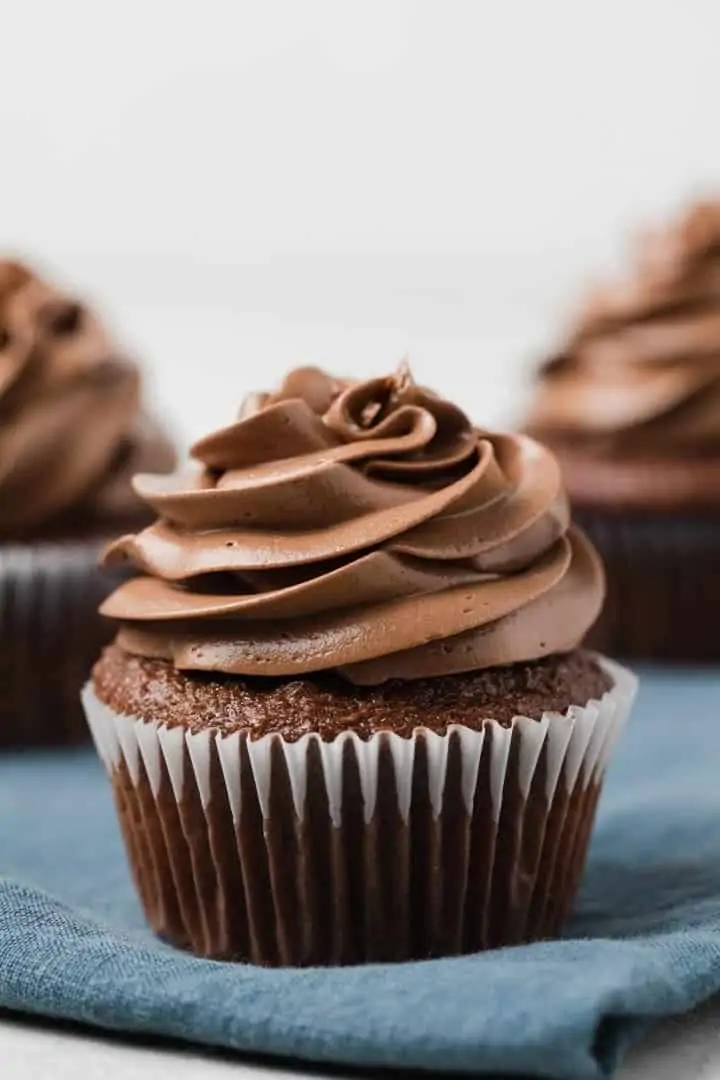 side view of chocolate cupcake with chocolate Swiss frosting