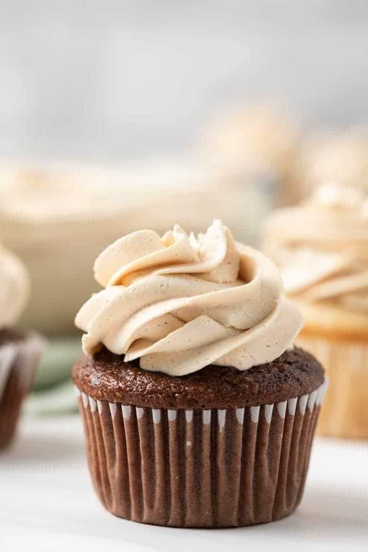 side view of peanut butter frosting piped over chocolate cupcakes