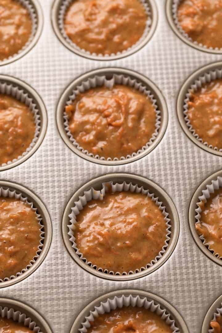 Muffin batter in paper lined muffin tin.