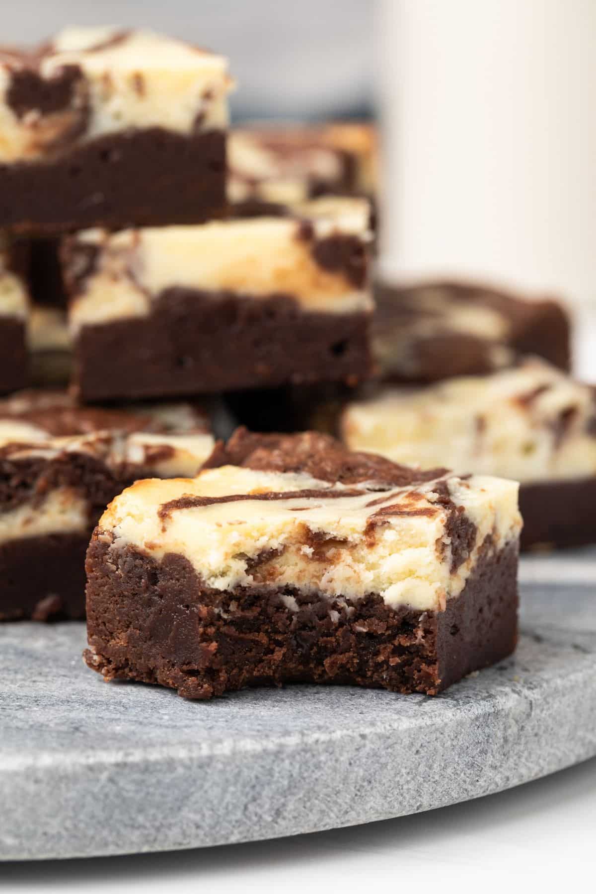 Close up of cream cheese brownie with a bite taken out.