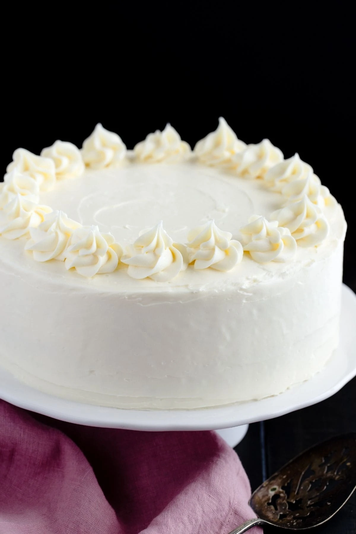 Homemade homemade vanilla cake on a white cake stand.