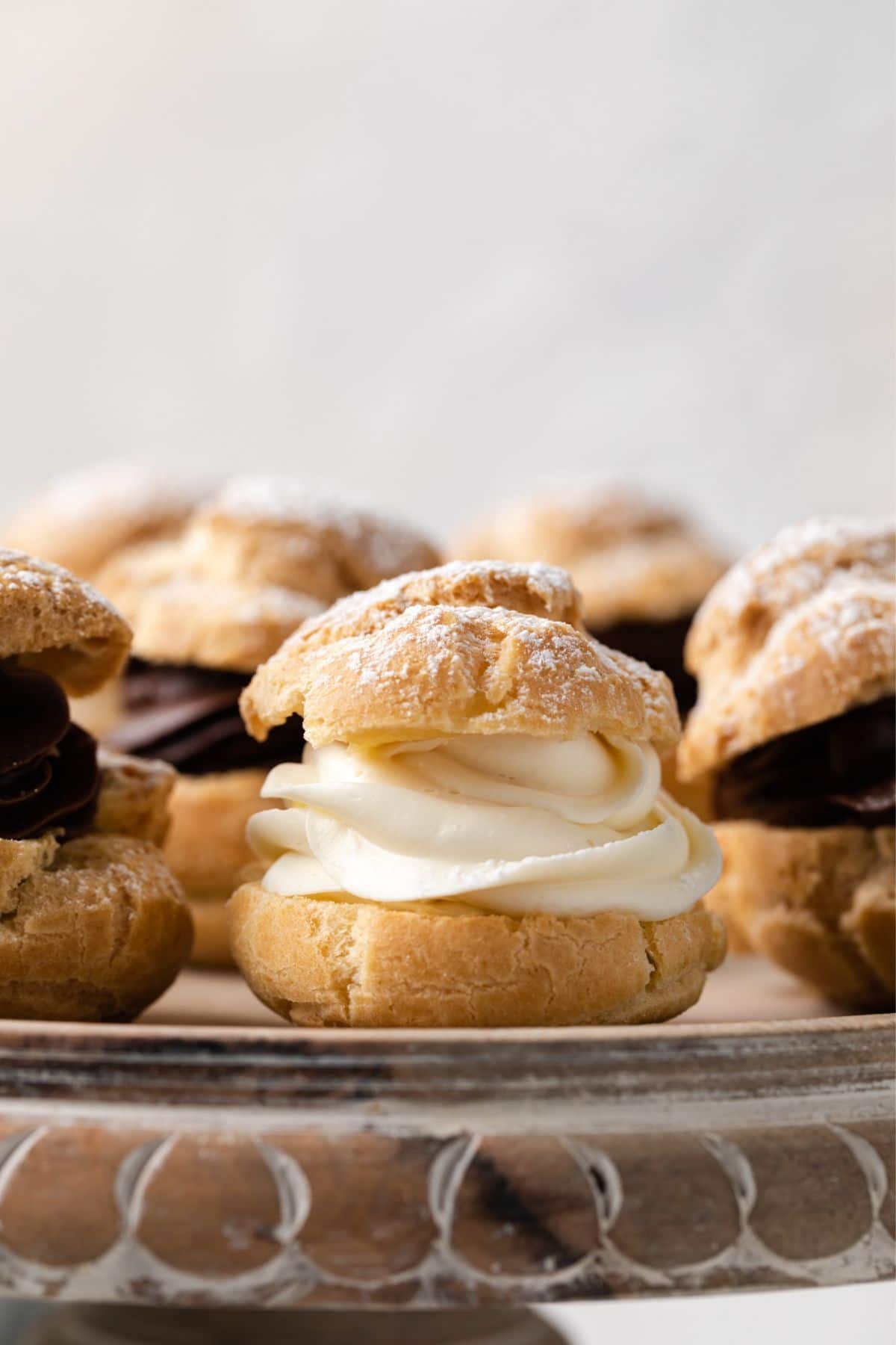 Side view of cream puffs filled with whipped cream and dusted with powdered sugar.