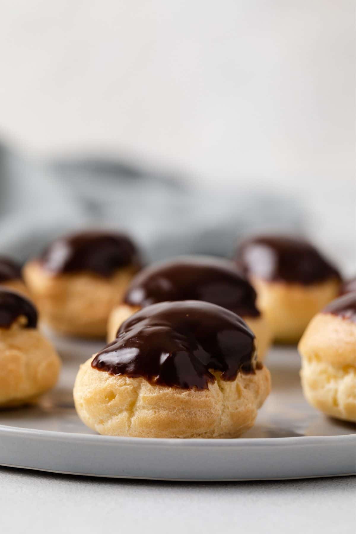 Side view of profiteroles topped with chocolate glaze.