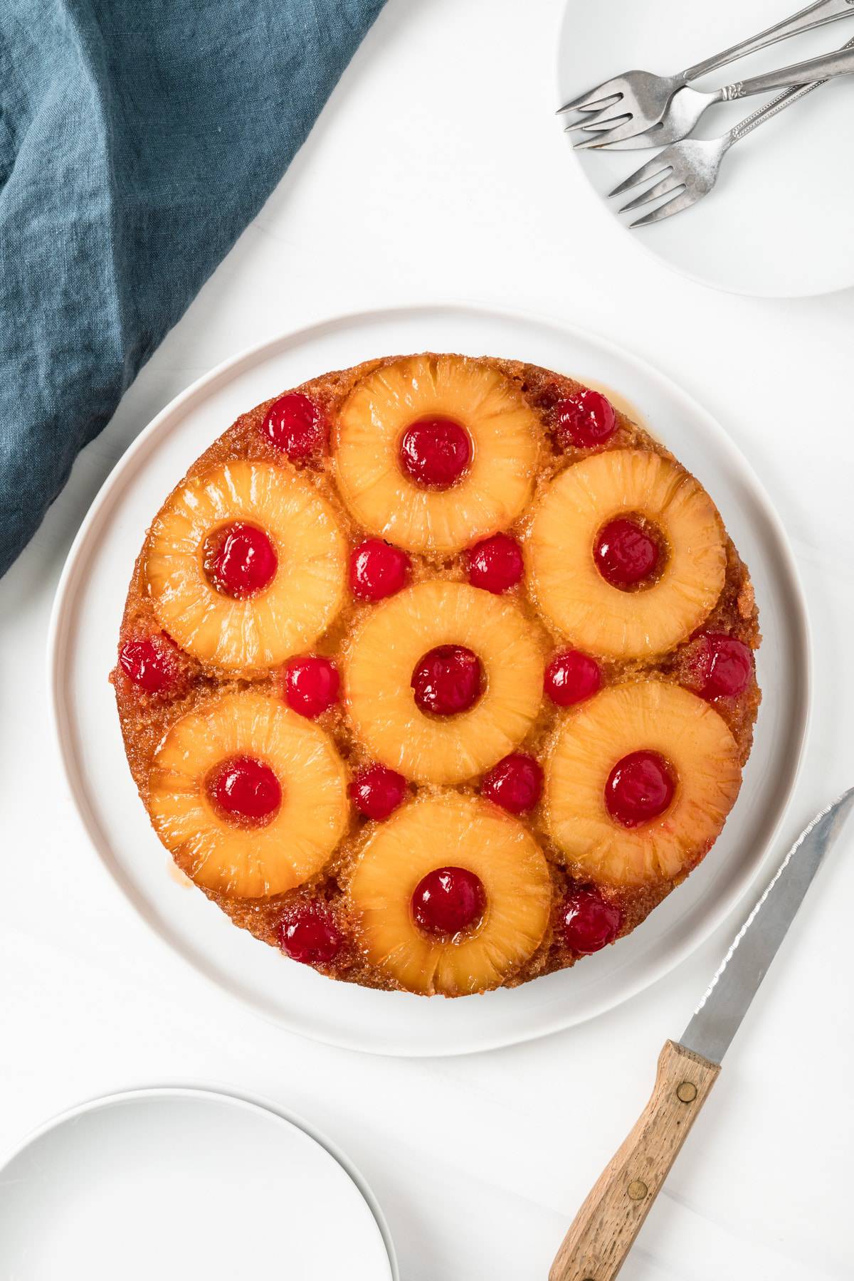 overhead of whole pineapple cake topped with pineapple rings and cherries