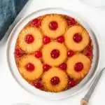 overhead of whole pineapple cake topped with pineapple rings and cherries