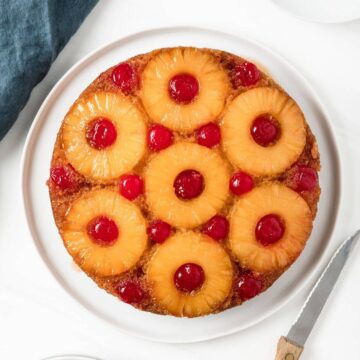 overhead of whole pineapple cake topped with pineapple rings and cherries