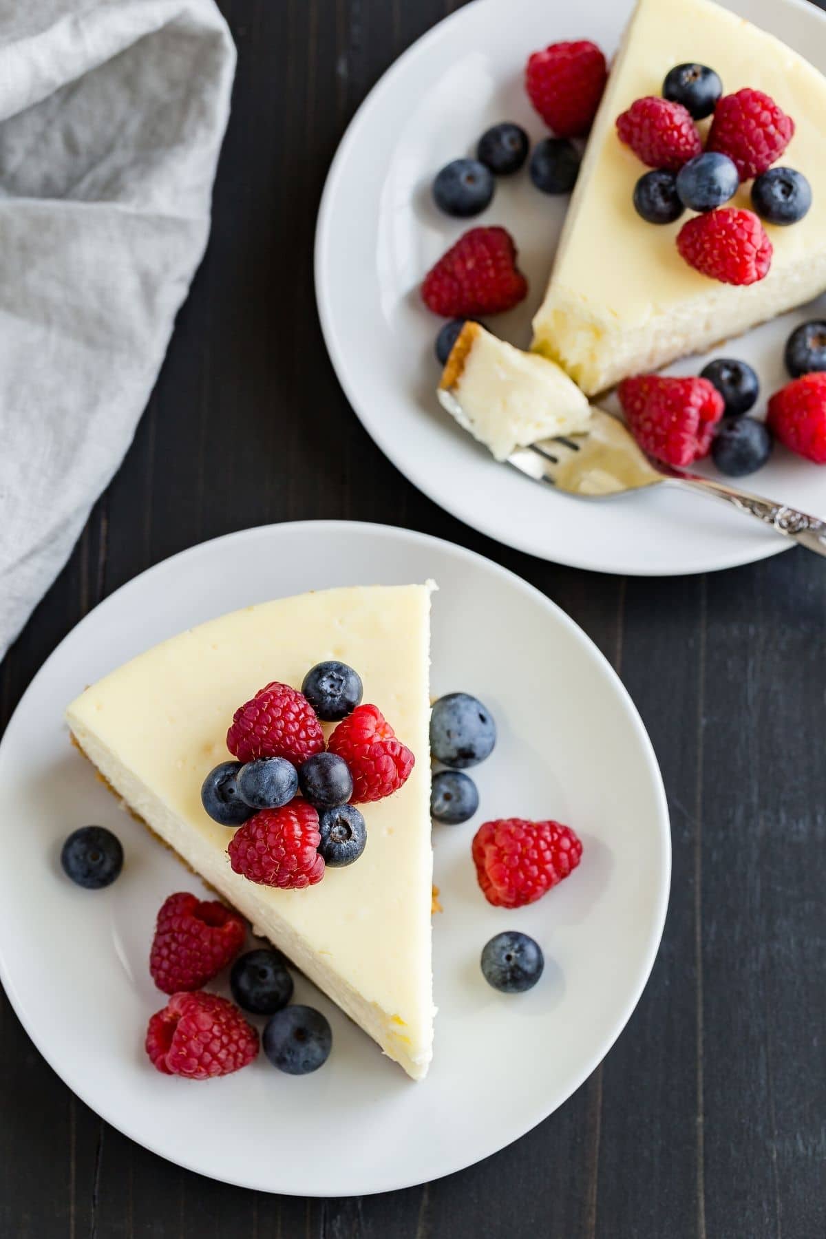 slice of cheesecake topped with fresh berries on a white plate