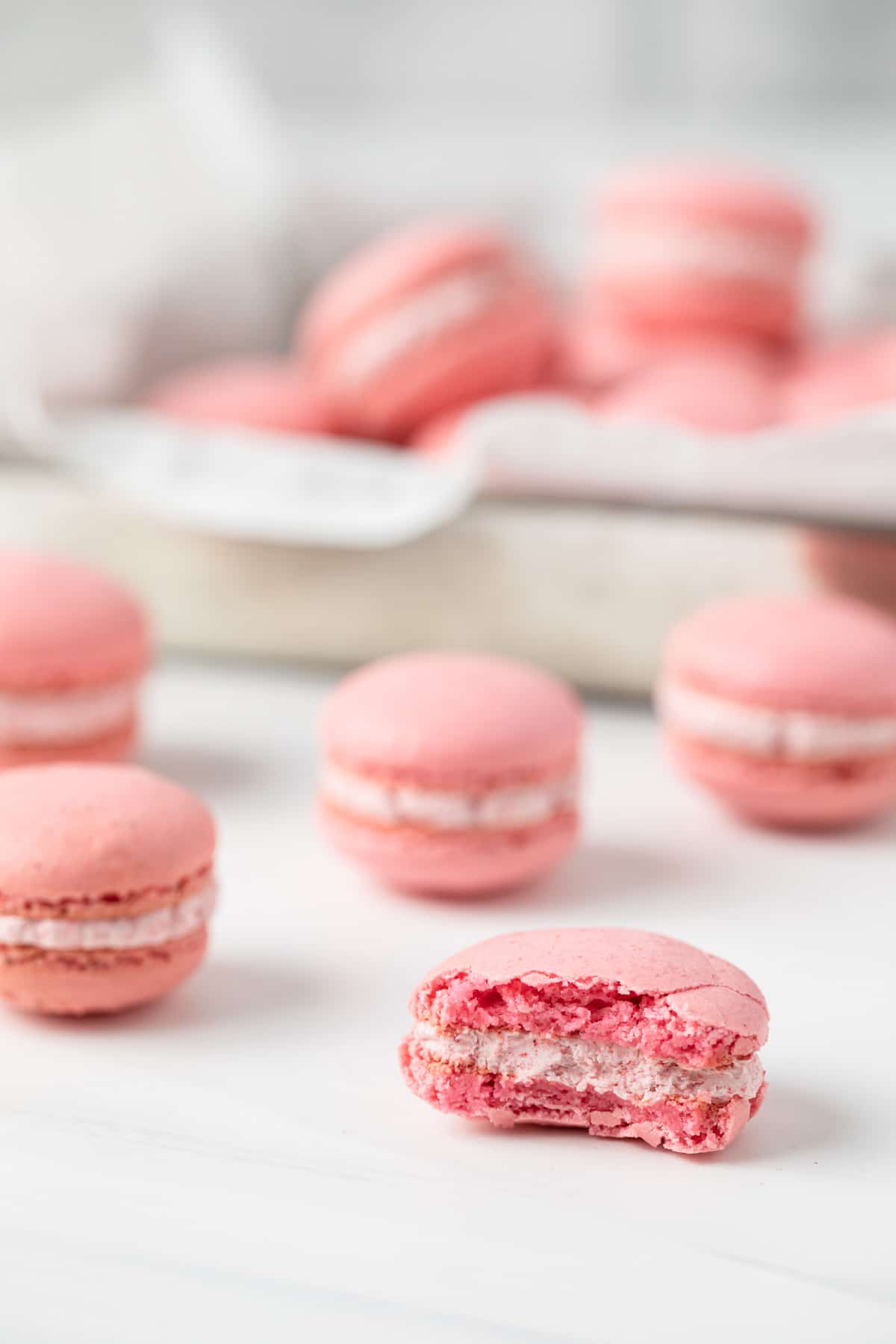 strawberry macaron with a bite taken out so the inside is visible