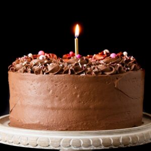 chocolate frosted cake with lit candle