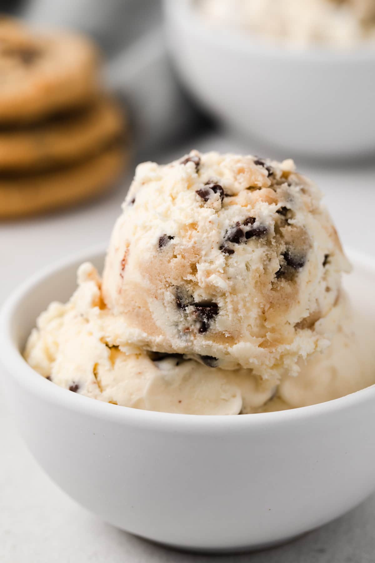close up of chocolate chip cookie dough ice cream scooped into white bowl