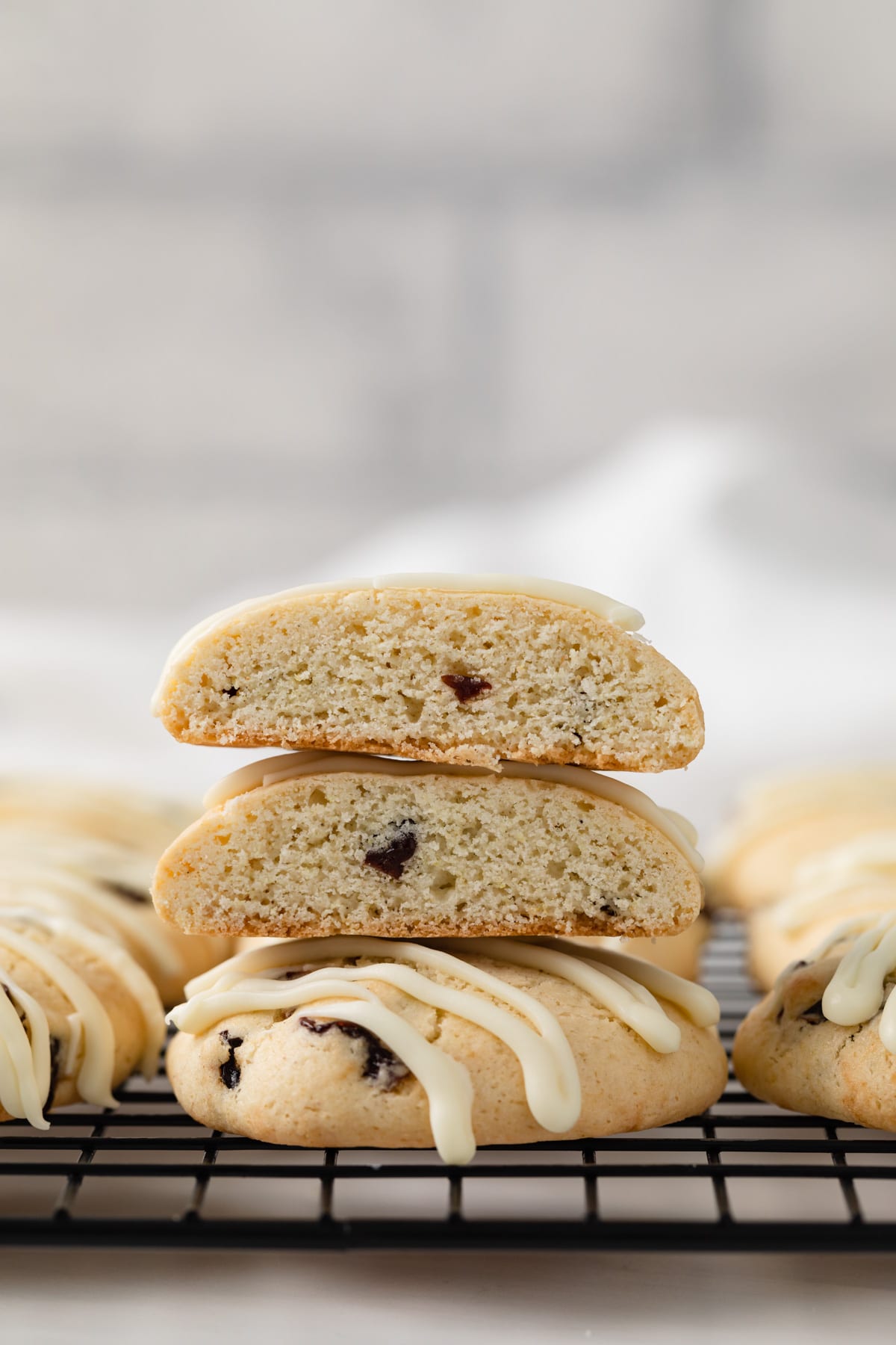 cherry almond cookies on a wire rack with two halves set over a whole cookie