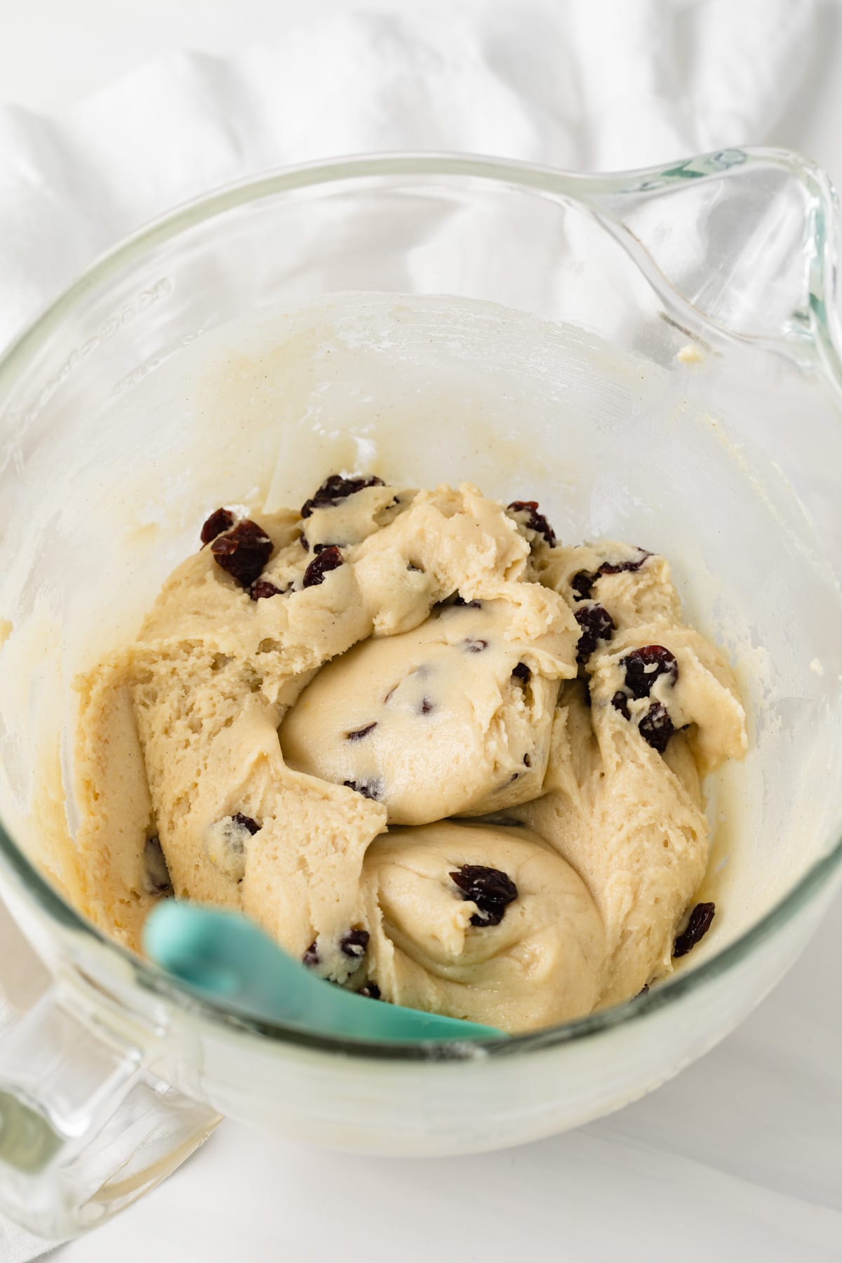 cherry almond cookie dough in glass bowl with teal spatula