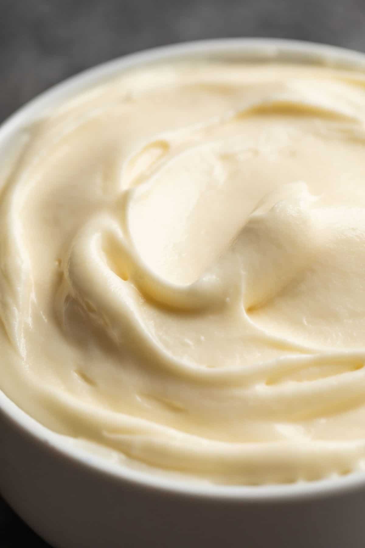 Close up of cream cheese frosting in a white bowl