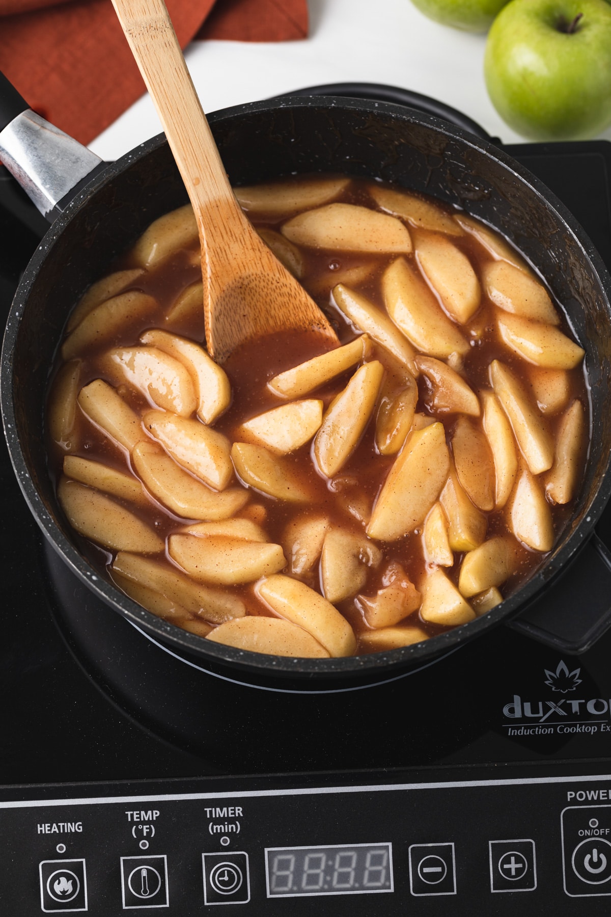 apple pie filling in pot with wooden spoon