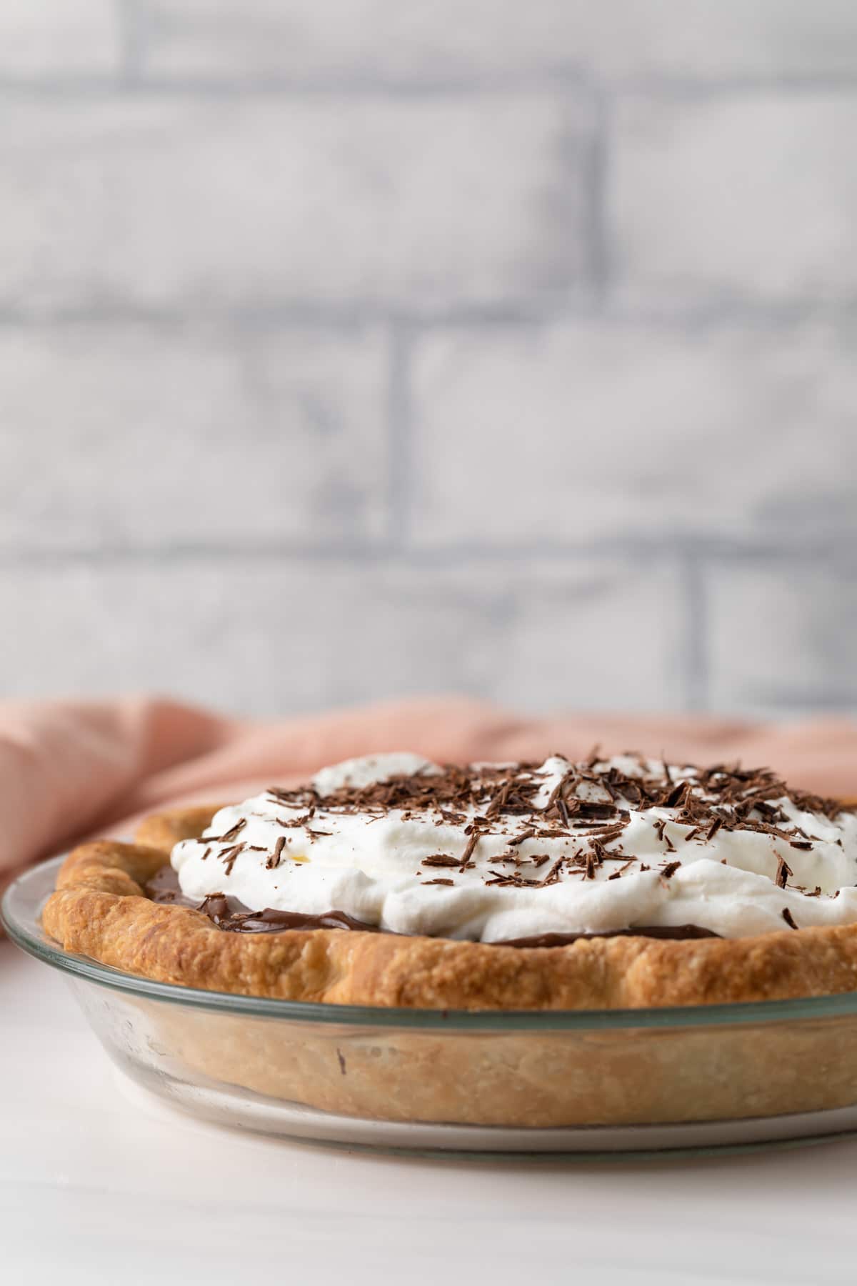 side view of chocolate pie with whipped cream in a pre-baked pie crust