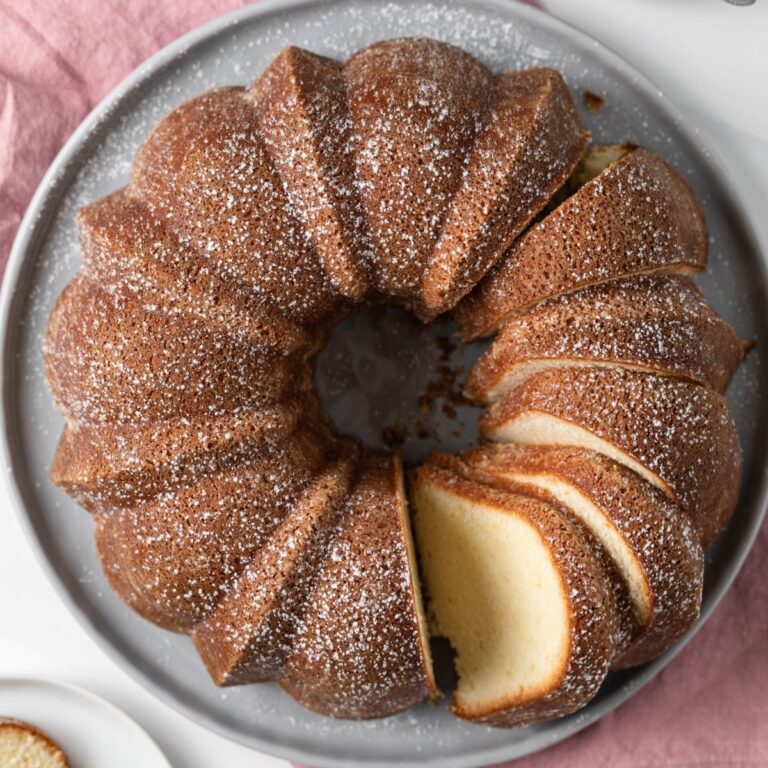 overhead of sliced pound cake on grey plate with pink napkin