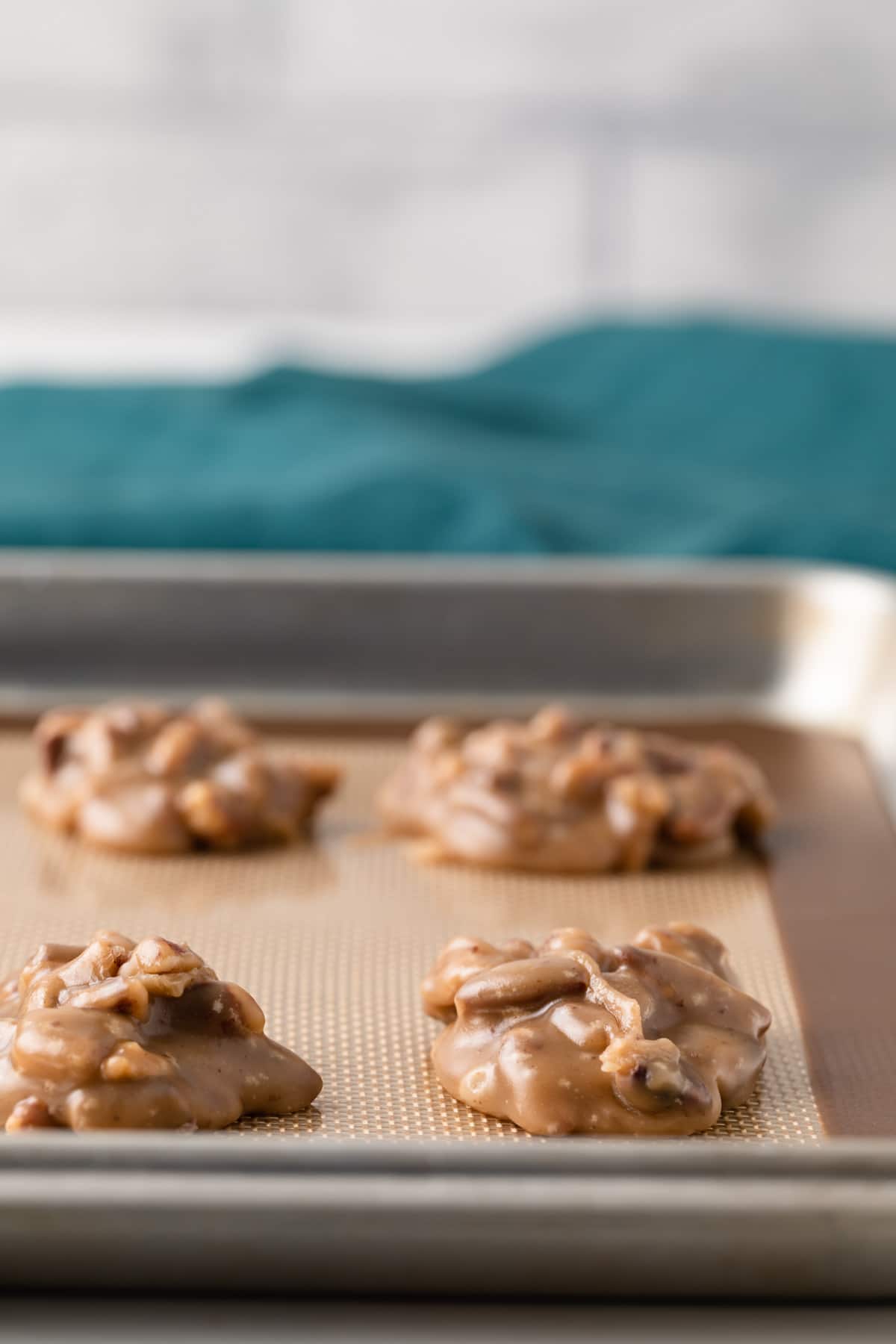 praline pecans on a baking sheet line with silicone mat