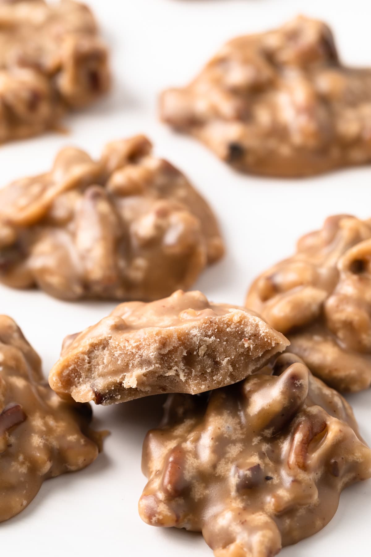 praline pecans arranged on white background with one broken in half so center is visible