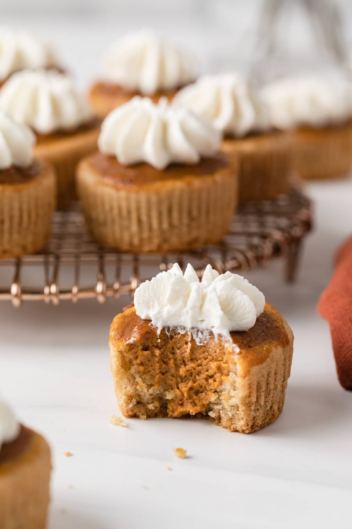 side view of mini pumpkin pie with a bite taken out so the inside is visible