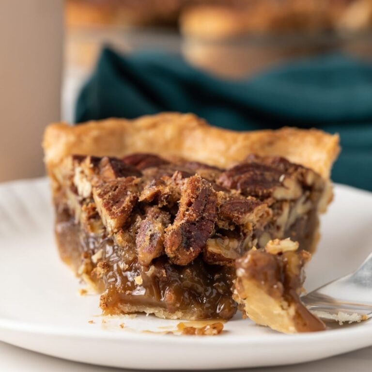 slice of pecan pie with fork taking a bite out