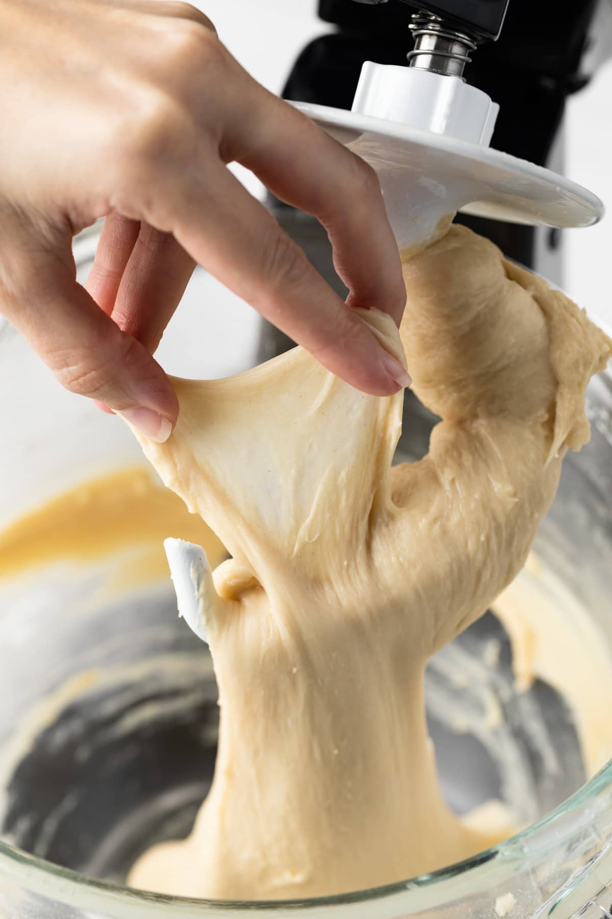 hand stretching dough to show window pane test